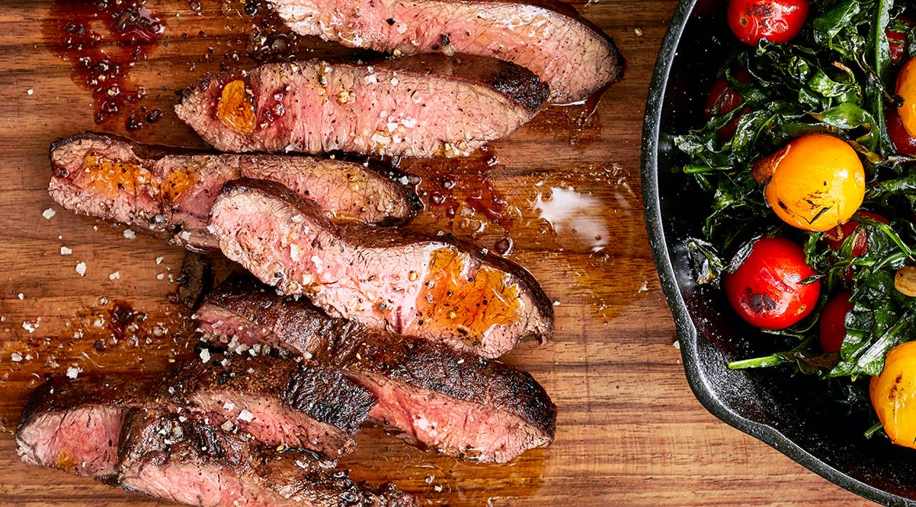 Flatiron Steak on cutting board with tomatoes